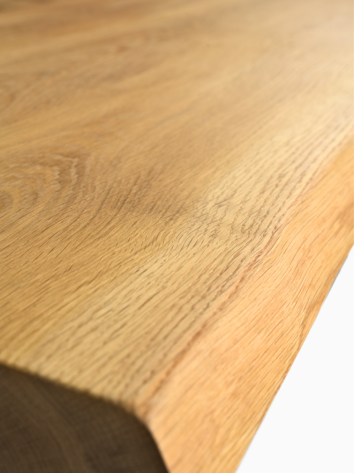 Detailaufnahme der Massivholz-Tischplatte aus Eiche mit natürlicher Baumkante und markanter Maserung
